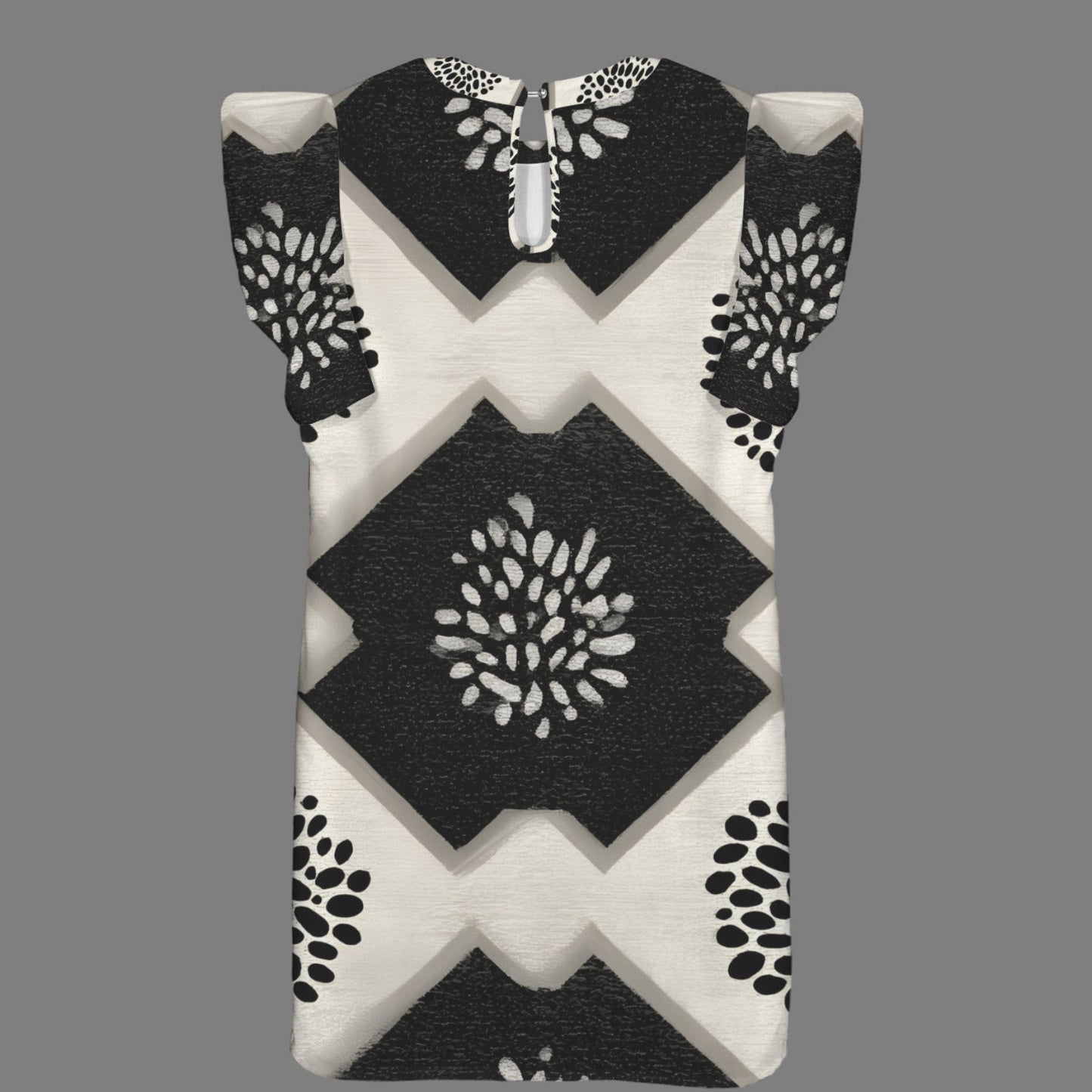 A sleeveless baby dress with a black and off-white geometric pattern featuring diamond and chevron shapes, displayed on a solid gray background.