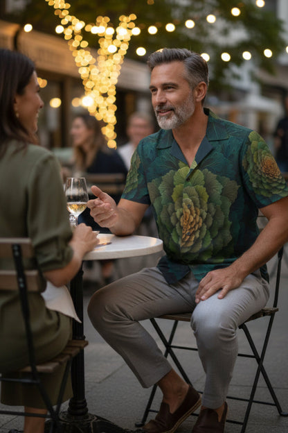 Man and woman sitting at a table outdoors with string lights in the background