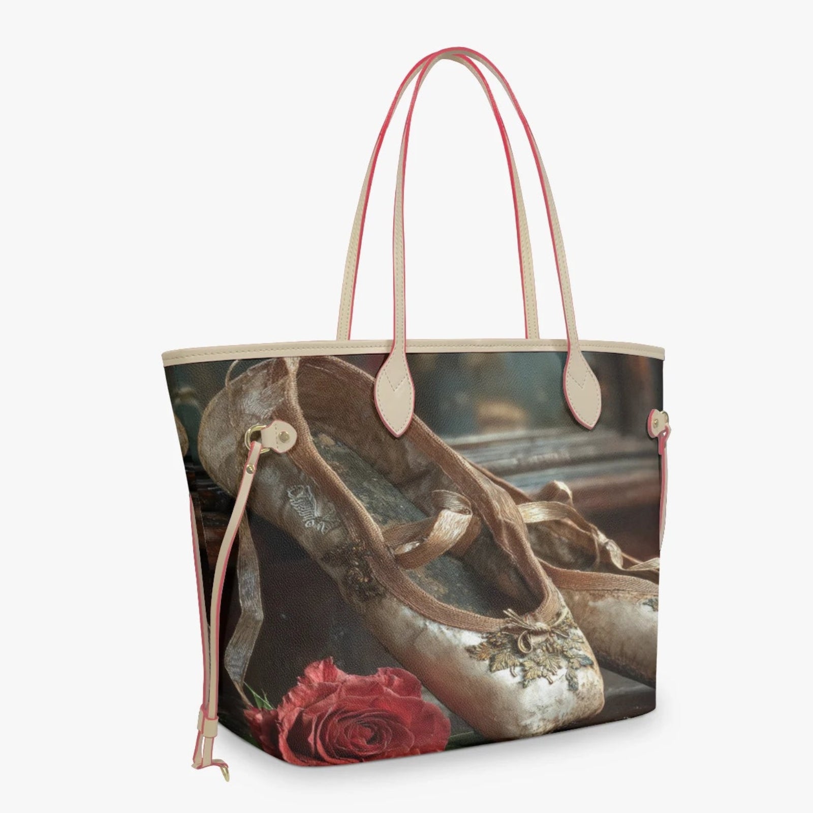 A tote bag featuring a printed graphic of vintage ballet slippers and a red rose, with light pink leather handles and trim, shown against a plain light gray background.