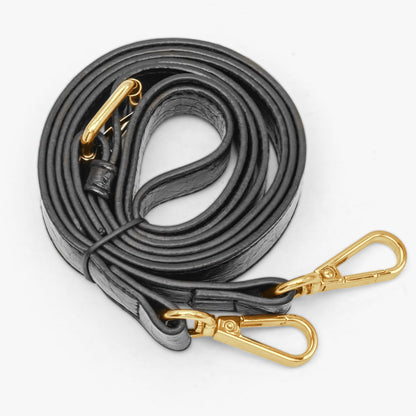 Black leather strap with gold hardware on a white background