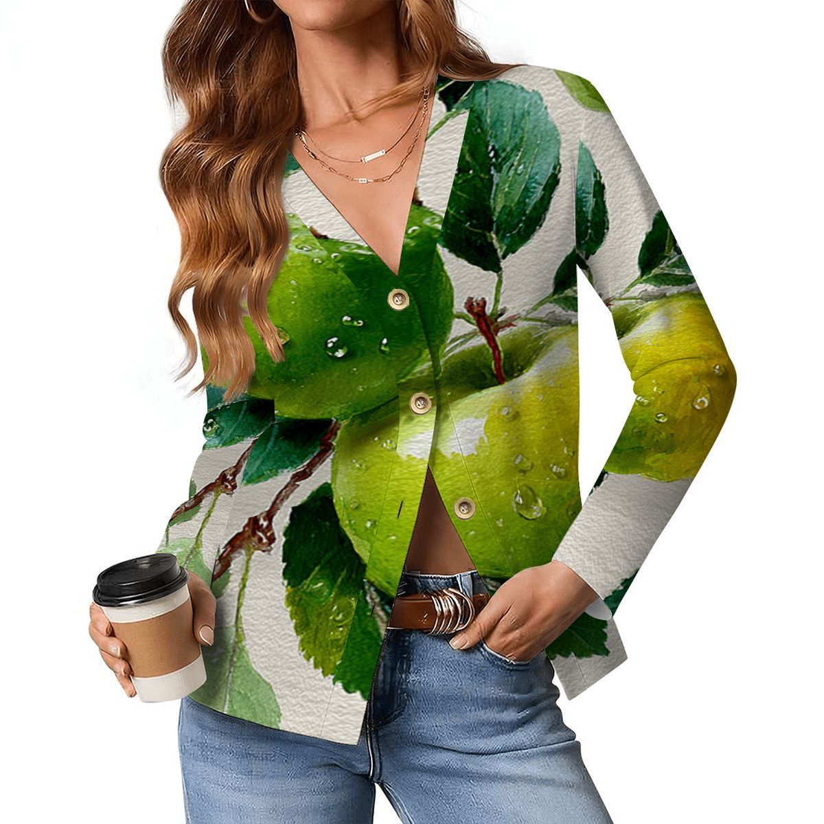 Person wearing a cardigan with green leaf pattern holding a coffee cup.