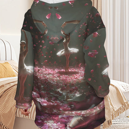 A person shown from the back wearing a long hooded sweatshirt with an all-over fantasy-style print featuring ballerinas, pink petals, and a dark green base, photographed in a bedroom setting.