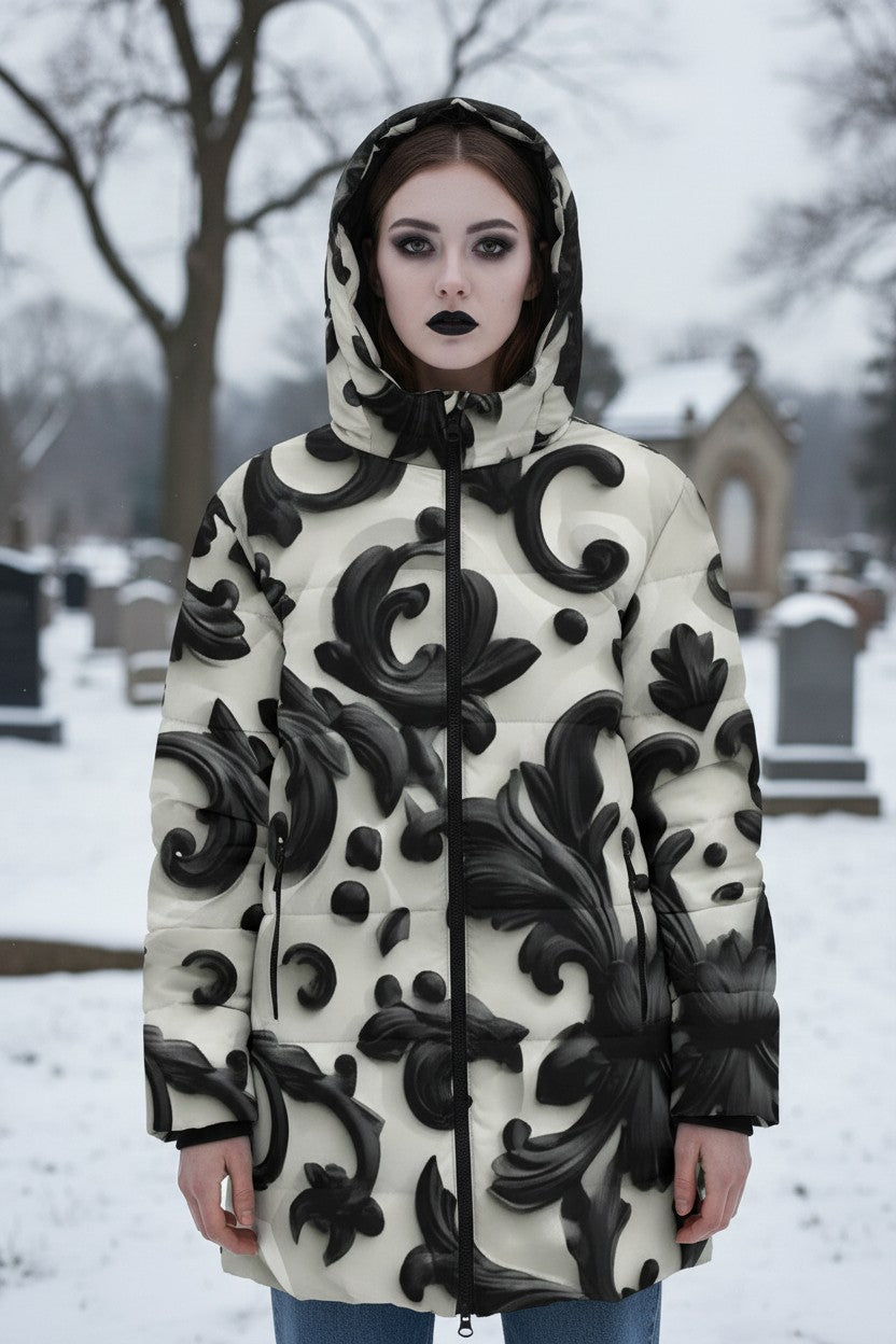 A model wearing a hooded puffer jacket with a black and cream 3D baroque scroll pattern, standing in a snowy cemetery.
