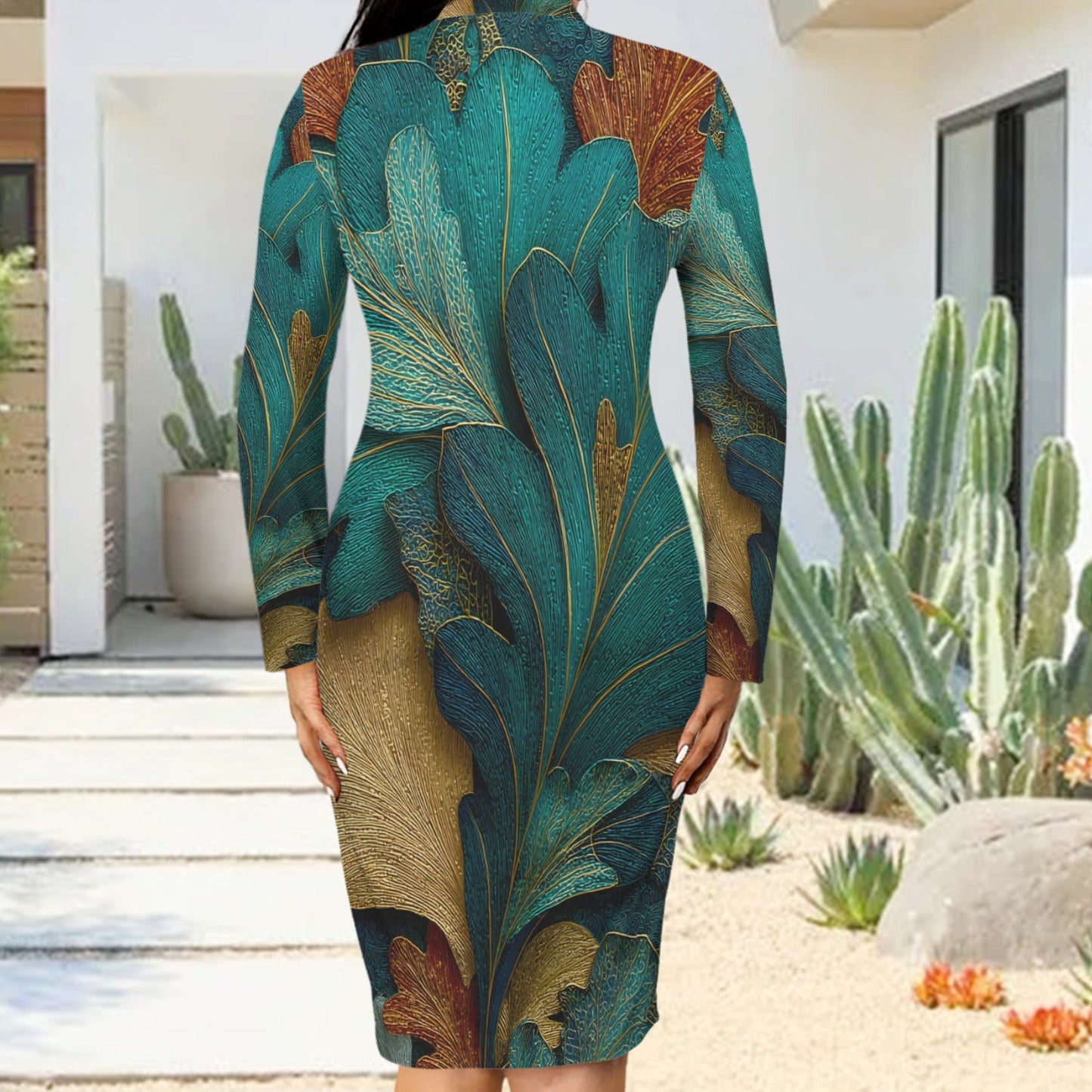 A woman wearing a long-sleeve bodycon dress with a large-scale botanical leaf print in teal, green, gold, and brown, photographed from behind in an outdoor patio setting with cacti.