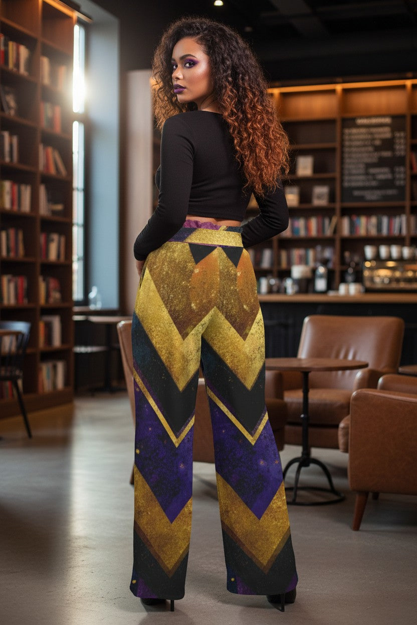 A woman stands in a bookstore wearing high-waisted, wide-leg trousers with a bold chevron pattern in gold, purple, and black, paired with a black long-sleeve top.