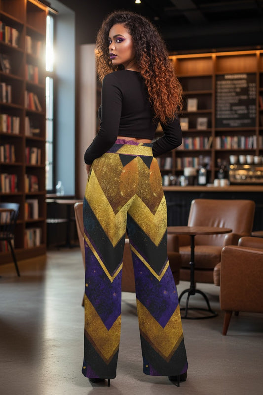 A woman stands in a bookstore wearing high-waisted, wide-leg trousers with a bold chevron pattern in gold, purple, and black, paired with a black long-sleeve top.