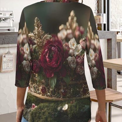 A woman wearing a three-quarter sleeve top with a detailed vintage-style floral print, shown from behind in a cafe setting.
