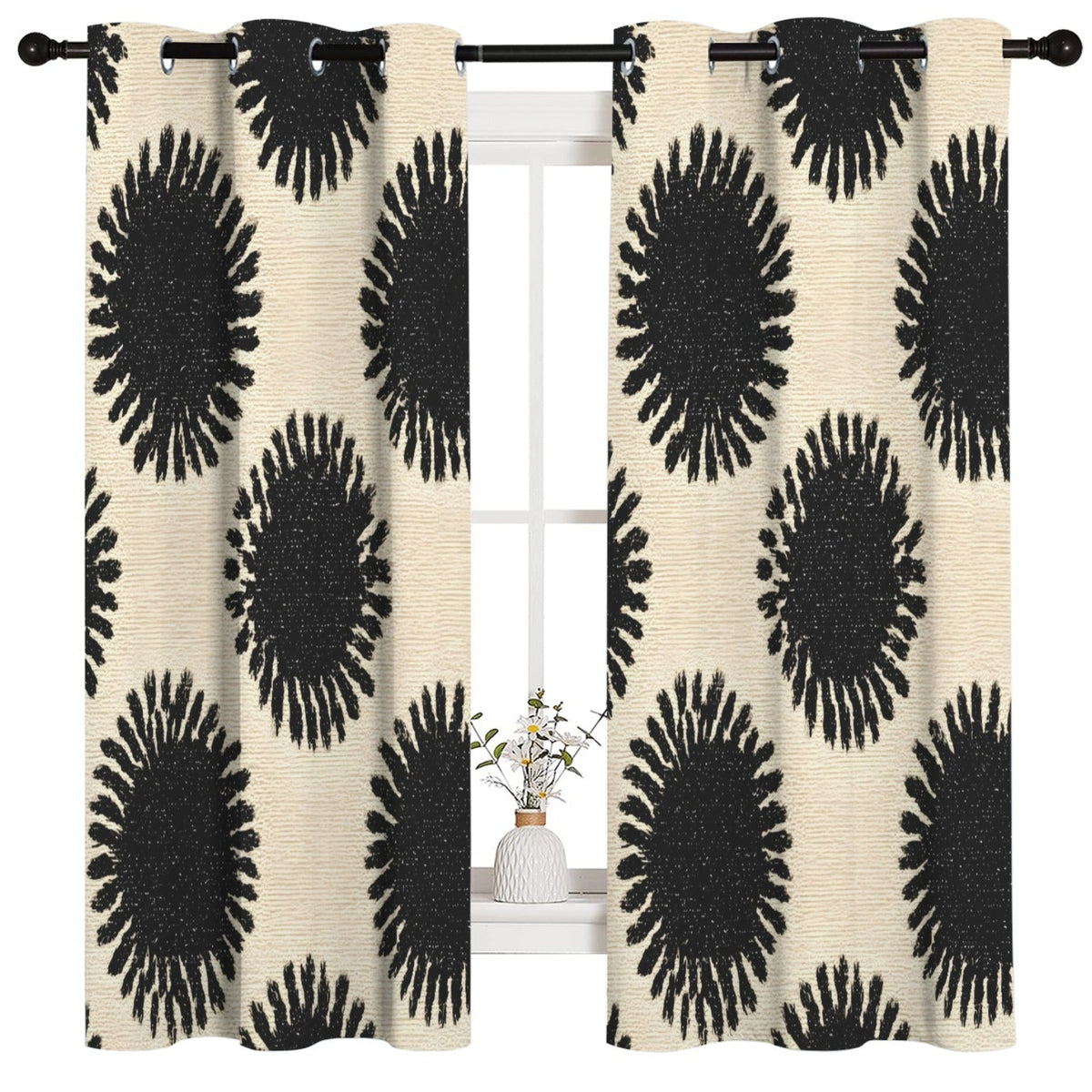 A pair of grommet-top window curtains with a bold black and cream abstract sunburst pattern, hanging on a black rod over a white window frame.