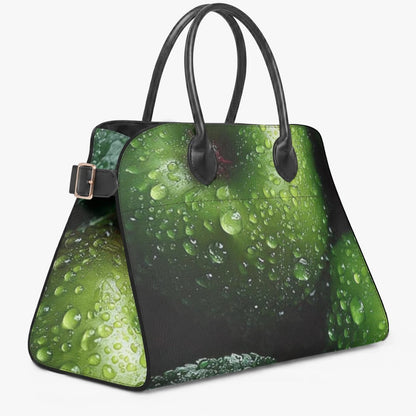 A structured handbag with a green water-droplet print on a black background, featuring black double shoulder straps and a silver-tone buckle detail on the side, set against a plain light gray background.