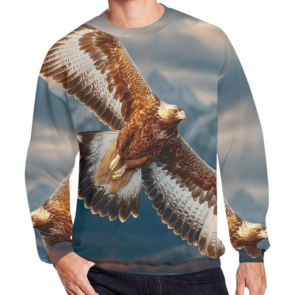 A man wearing a crewneck sweatshirt featuring a large, realistic print of a golden eagle in flight against a cloudy blue sky. The sweatshirt is shown on a model wearing dark jeans, set against a plain white background.