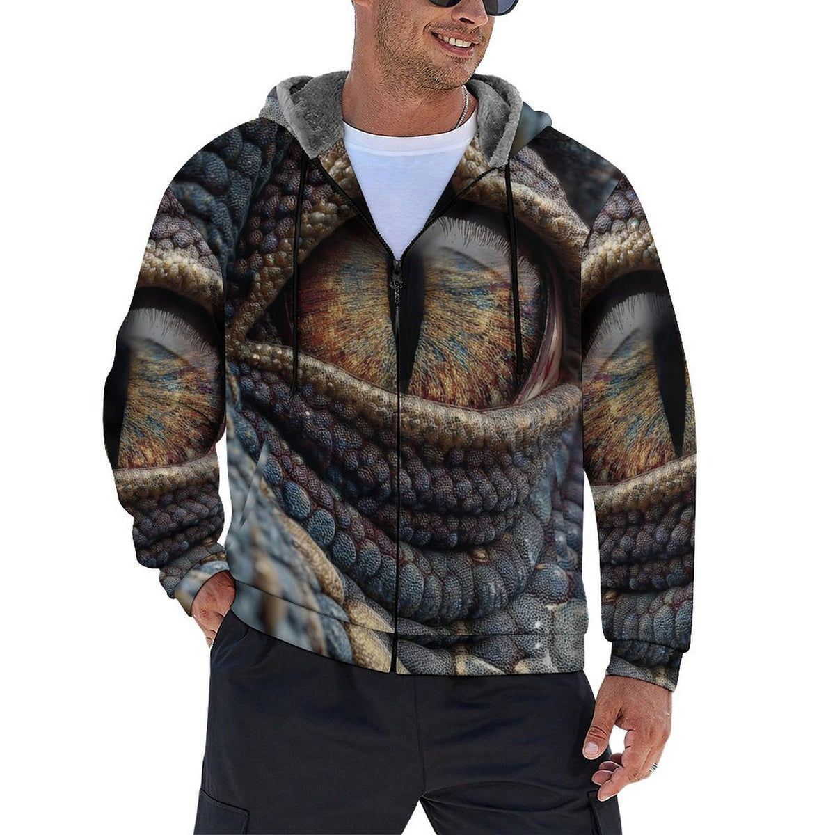 A man wearing a full-zip hoodie with an all-over 3D-printed design of a large textured eye, paired with a white t-shirt and black pants, shown against a plain white background.