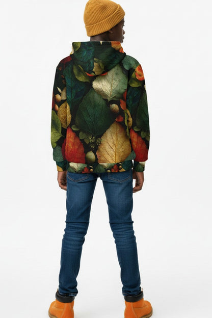 A person shown from the back wearing a hooded sweatshirt with an all-over autumn leaf print in green, red, orange, and beige, paired with blue jeans, a mustard yellow beanie, and orange boots, against a plain white studio background.