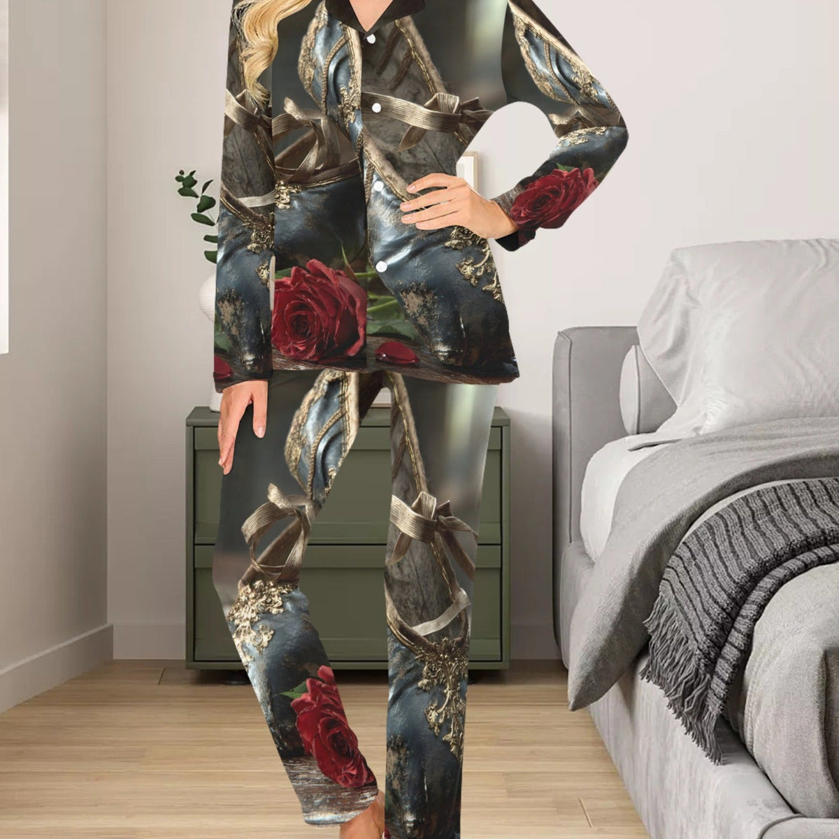 A woman modeling a matching pajama set with a dark, ornate baroque-style print featuring red roses, set in a bedroom environment.