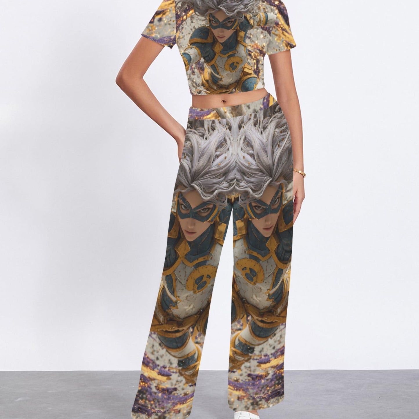 A woman modeling a matching two-piece set featuring a short-sleeve crop top and wide-leg pants, both printed with an abstract, symmetrical pattern in gold, gray, brown, and purple tones.