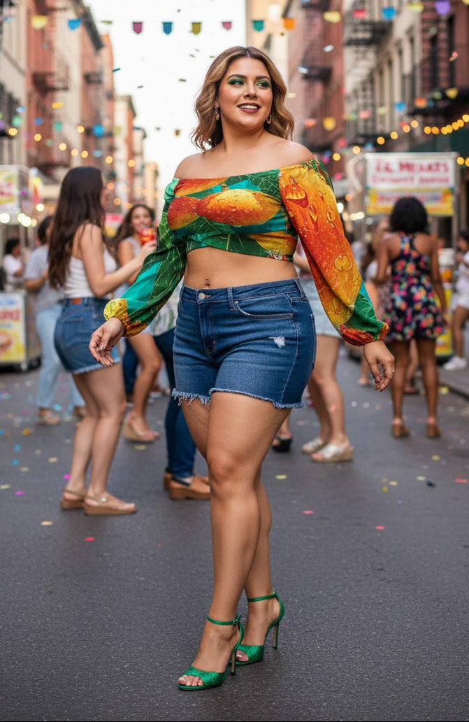 Woman in colorful top and denim shorts standing on a street with confetti, people, and colorful lights in the background.