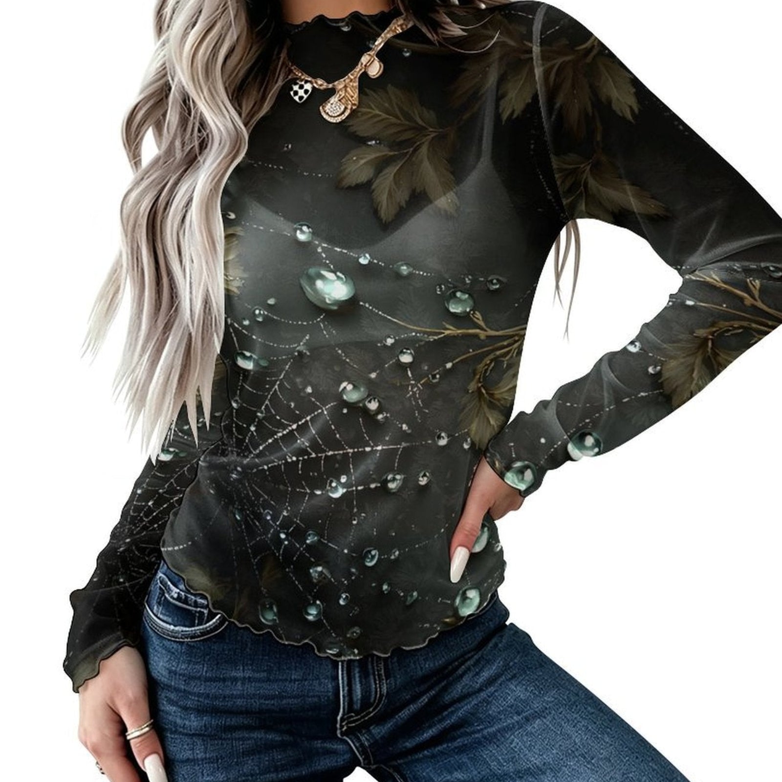 A woman wearing a long-sleeve black top with a spiderweb and dewdrop print, paired with blue jeans, shown against a plain white background.