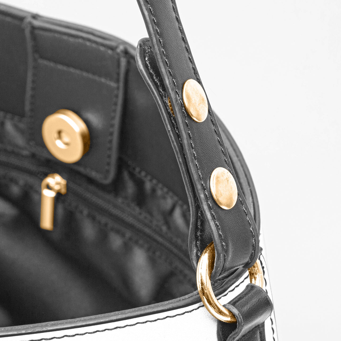 Black handbag with gold hardware on a white background