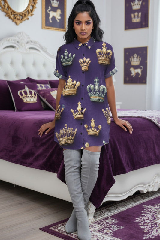 A woman in a button up shirt dress leans on her royal themed bed