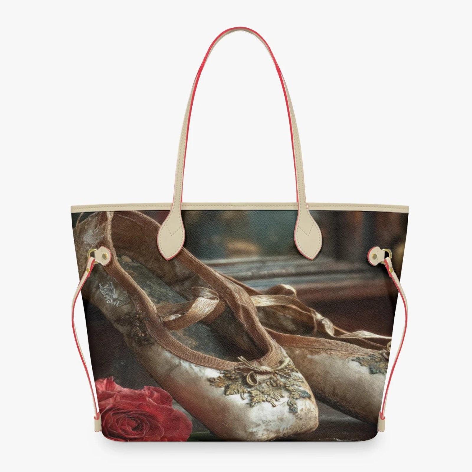 A tote bag featuring a printed design of vintage ballet slippers and a red rose, with light beige leather handles and red drawstring side details, shown against a plain white background.