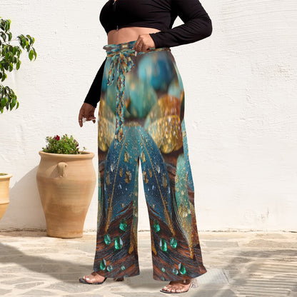 A person wearing high-waisted wide-leg pants with a colorful peacock feather print, styled with a black long-sleeve crop top and clear heeled sandals, standing outdoors against a white wall.