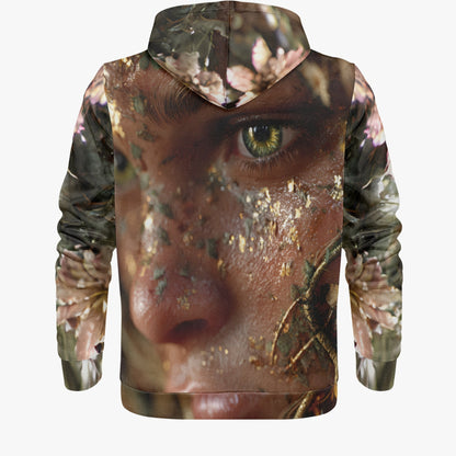 A pullover hoodie shown from the back, featuring an all-over photographic print of a close-up human face with a green eye, overlaid with a camouflage pattern and pink floral elements, on a light gray background.