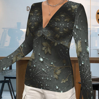 A woman wearing a long-sleeve wrap-style top with a dark abstract floral print, paired with light cargo pants, standing in a modern retail interior.