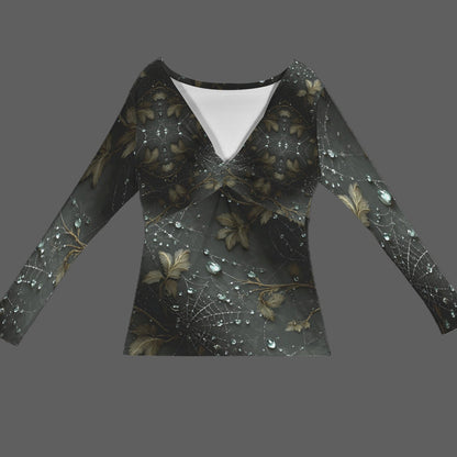 A long-sleeve V-neck top with a dark, gothic-style print featuring spiderwebs, spider legs, and gold-toned leaves with sparkling rhinestone details, shown against a solid gray background.