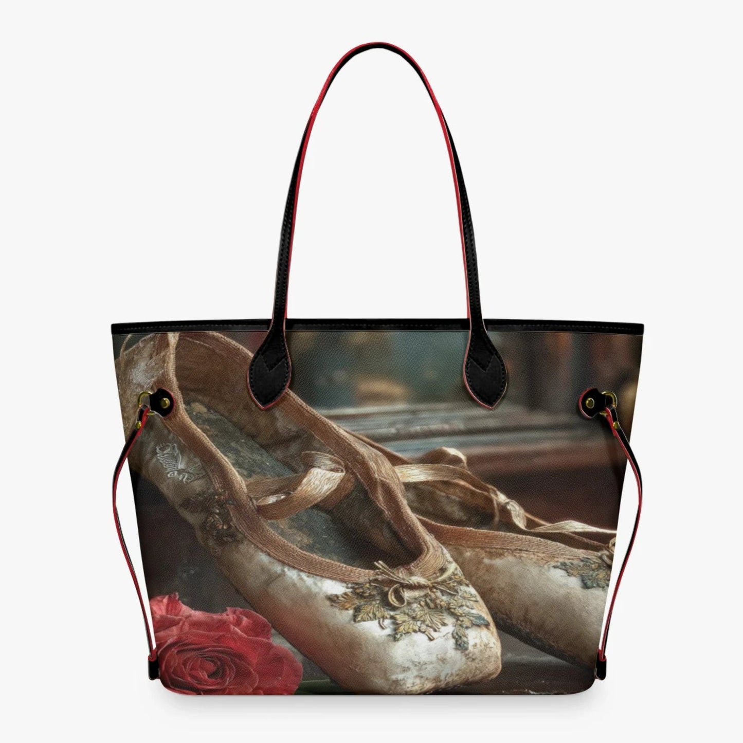 A tote bag featuring a printed design of vintage ballet pointe shoes and a red rose, with black and red shoulder straps, shown against a plain white background.