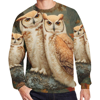 A man wearing a crewneck sweatshirt featuring a detailed all-over print of four great horned owls in naturalistic brown, beige, and gray tones against a muted forest background.